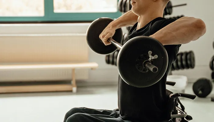 An athlete lifting a barbell from his wheelchair